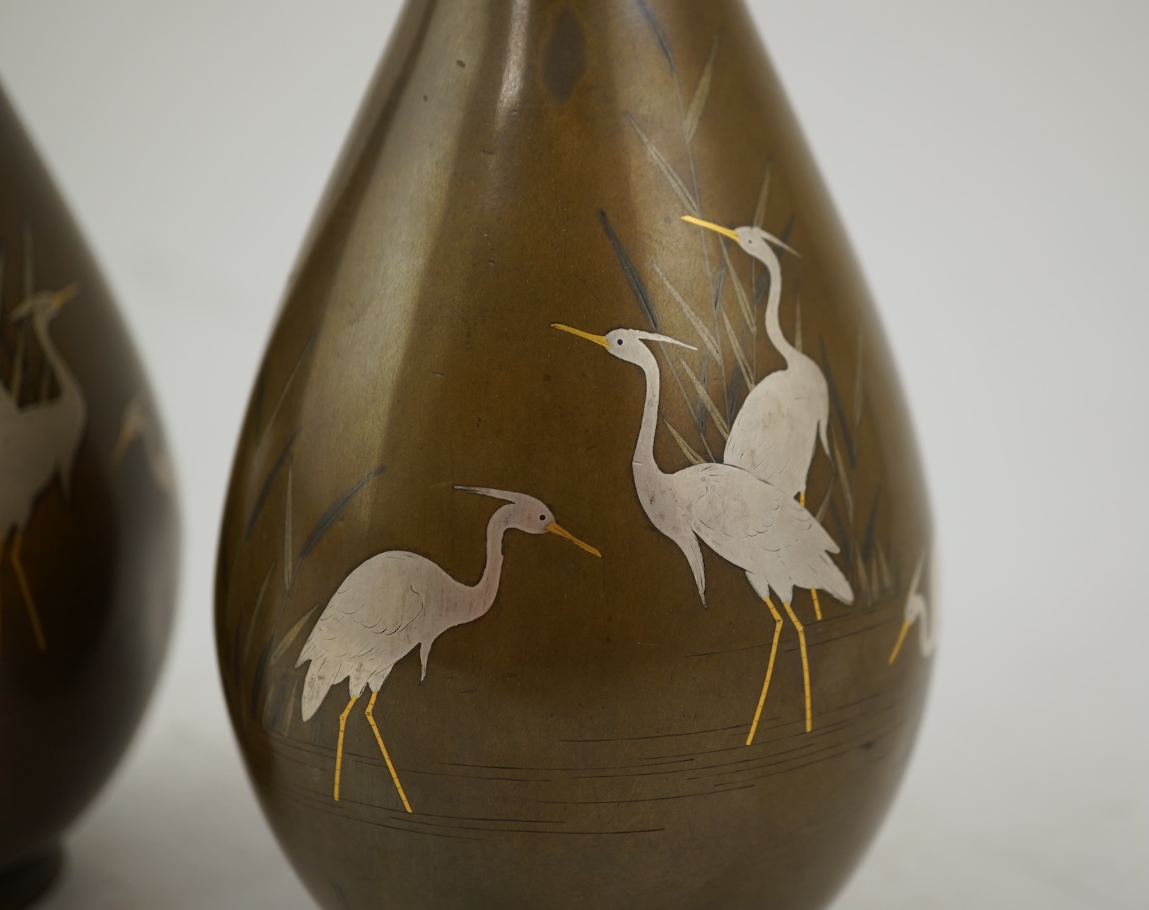 A pair of Japanese bronze and mixed metal inlaid bottle vases, signed Hidemitsu, Meiji period
